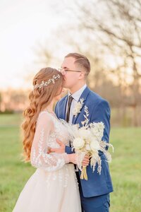 A groom kisses his bride's forehead at this Charlotte wedding venue.