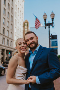 Husband and wife hold hands and smile in downtown Nashville Tennessee