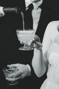 groom pouring champagne in glass