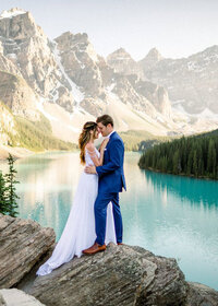 Portrait of a bride and groom standing face to face in Banff at Moraine Lake Alberta