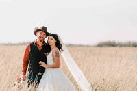 Bride and groom stand with their bridal party in some trees. Captured by Amanda Jordan Photography.