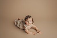 6 month old girl posed on beige during milestone session in Tampa