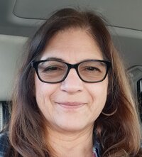 Client Leticia smiling at camera  wearing black glasses