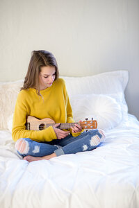 Tween girl playing guitar in photo studio in Boise.