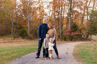 Family standing on a trail with the fall foliage