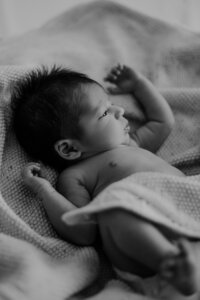 black and white newborn image under a blanket