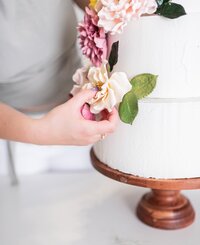 styling sugar flowers on a wedding cake close up
