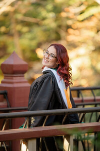 college graduate popping spraying champagne in graduation gown at williaam & mary Wren Building