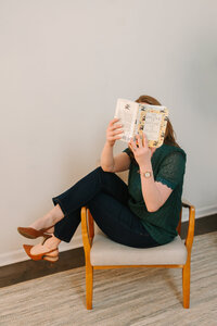 Lindsay playfully holding  book over her face