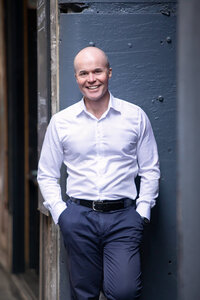 A male life coach leaning against wall in Melbourne