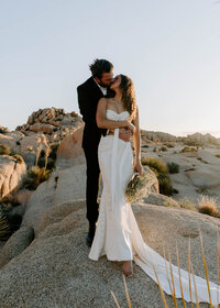 man carries woman in desert for Palm Springs elopement