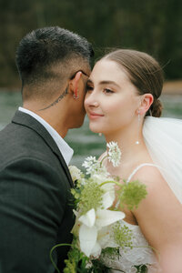 Intimate lakeside wedding ceremony capturing the heartfelt vows of a couple in British Columbia.