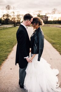 Bride and Groom with heads pressed together and Bride wearing a leather jacket