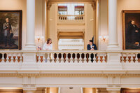 A couple stands on opposite ends near columns
