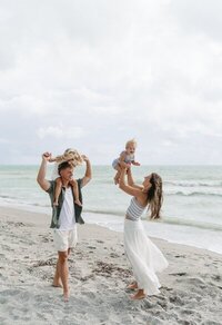 engagement photography florida of couple playing on a beach, taken by Shelby Ann Photos