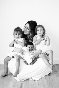 mom with three kids in black and white