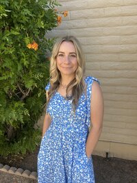 Woman standing outside in front of a flowering tree, smiling