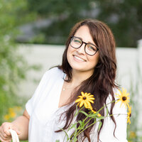 Woman smiling outside holding some wildflowers