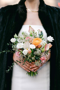 A bride holds a chic wedding bouquet on her city hall wedding day.
