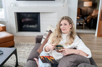 Okanagan interior designer sitting in modern living room reading magazine for modern brand photos session