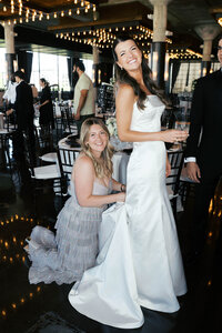Brooke Romere adjusting brides bustle before reception- Owner of Everlasting Events wedding planning in Austin, Dallas, and Houston Texas 