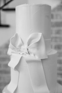 black and white photo of simple white cake with a big bow