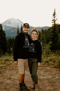Wedding planning team posing in front of Mount Rainier after hiking with couple for an elopement!