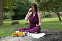 Jennifer sitting on a blanket outdoors with flower essences