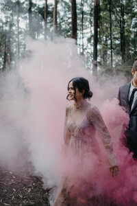 bride emerges from pink smoke in sparkly dress