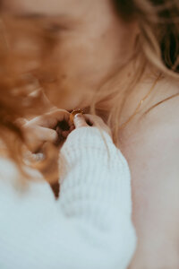 Parent holding baby in soft natural light, photographed by Sydney newborn photographer Sophie Lea.