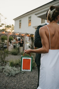 bride holding glass and bag