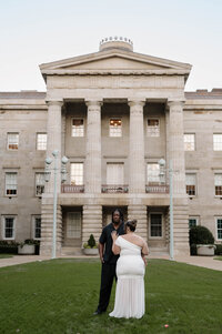 A black and white flash photography photo of a couple on their wedding day in Durham NC. They're in an outdoor garden that looks like a fairytale.