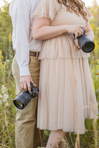 Mark and Meredith holding Canon R6 camera's in flower field in Waukesha, Wisconsin.
