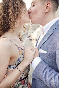 A newly engaged couple kissing with a closeup of the ring. Taken by Rome Photographer, Tricia Anne Photography.