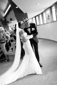 two flower girls in dresses peeking into the bridal suite