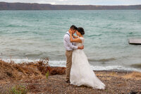 A couple embraces on the lakeshore of Laguna de Apoyo, Nicaragua at their wedding.