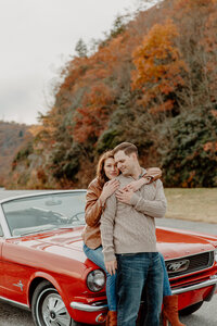 photo of couple sitting on a vintage car on the blue ridge parkway in asheville