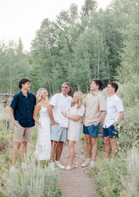 A large family explores the Sawmill Museum trails while laughing in summer
