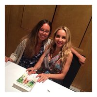 Meg O'Neill sitting with a happy woman at a table