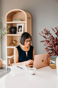 Smiling woman holding a book in her hands, symbolizing book coaching and guidance.