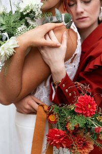 Cliché des mains enlacées de deux mariées lors du shooting d'inspiration mariage à Le Grand-Lemps