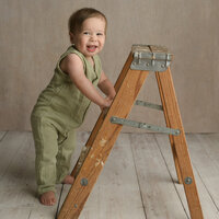 Happy one year old standing with ladder