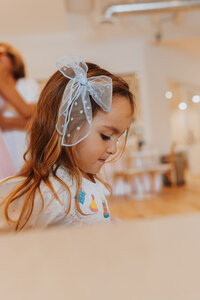 Little girl wearing a blue bow at a birthday party at JoyBabe Studio in La Mesa CA