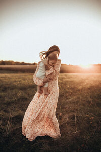 mother holding baby in field