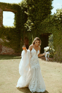 bride holding dress in a garden