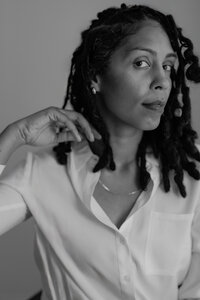 A sophisticated black-and-white portrait of photographer Nerissa James, capturing her confident and thoughtful expression.