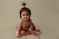 girl sitting on hardwood floor looking at camera