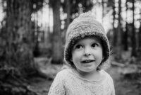 Black and white photograph of a toddler girl wearing a knit hat