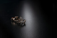 Close-up of wedding rings on a dark surface