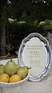 cocktail menu paired with fruit on a silver dish at a wedding featured in one of kate's content co. wedding content creation
